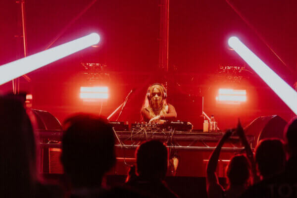 Princess Glitoris performs at AVA Belfast 2025 on the Pumphouse stage, framed by red lighting and white beams as the crowd watches.