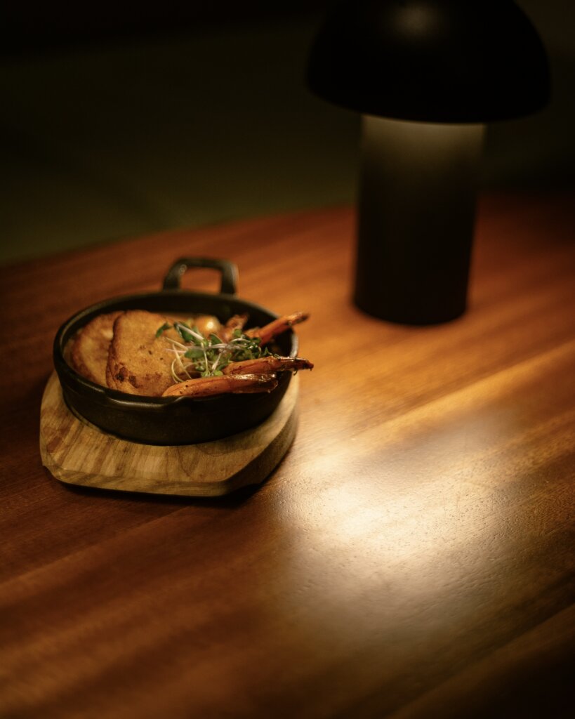 Photo of signature food dish on wooden table at IBILE restaurant